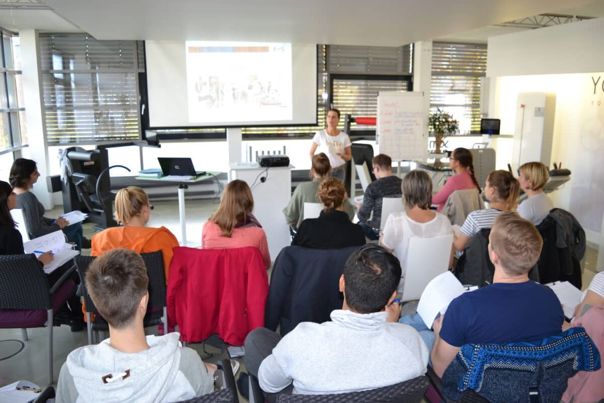 Referentin erklärt Inhalte der T-RENA-Fortbildung von YOLii vor einer Gruppe Physiotherapeuten